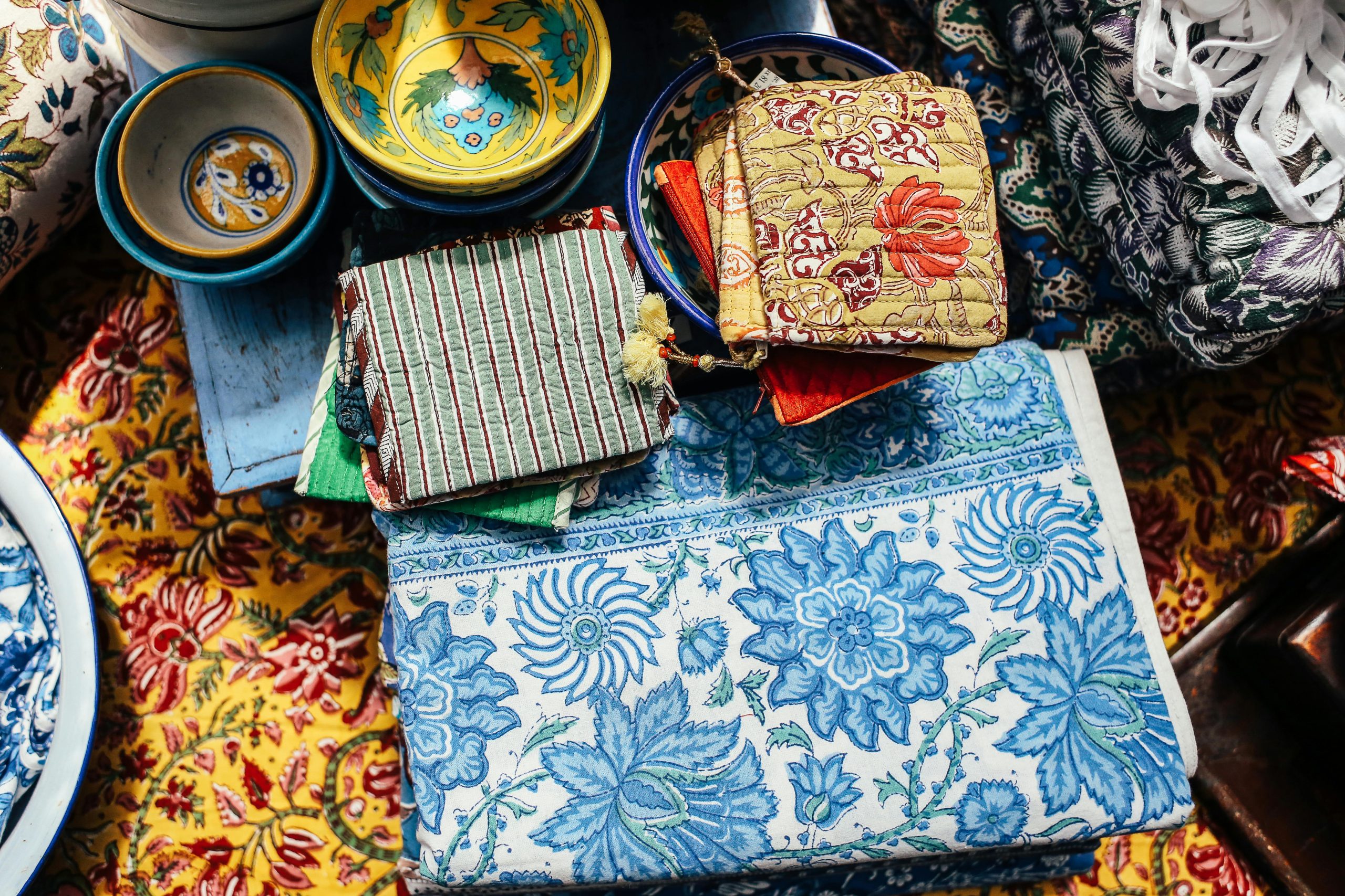 Brightly colored textiles and patterned bowls create an artistic display.